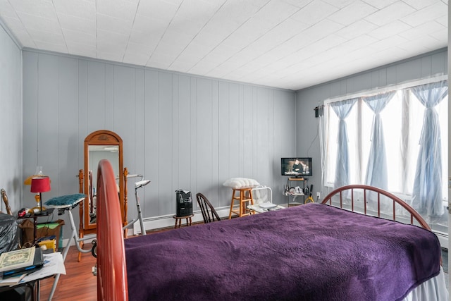 bedroom with wood-type flooring and wood walls