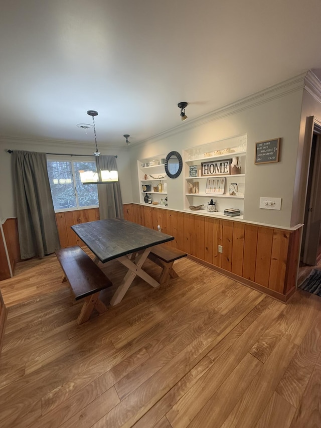 dining area featuring crown molding and light hardwood / wood-style flooring