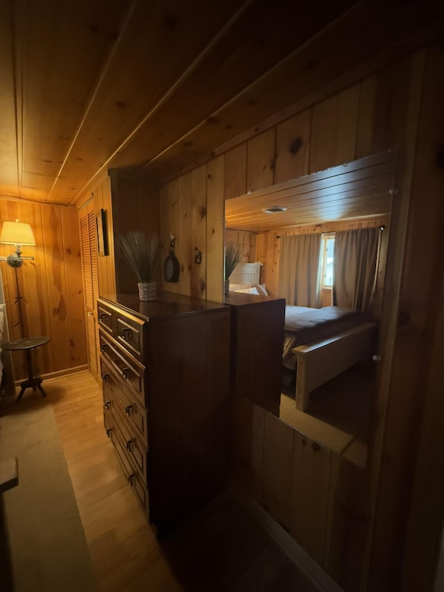 bedroom featuring wooden walls and light wood-type flooring