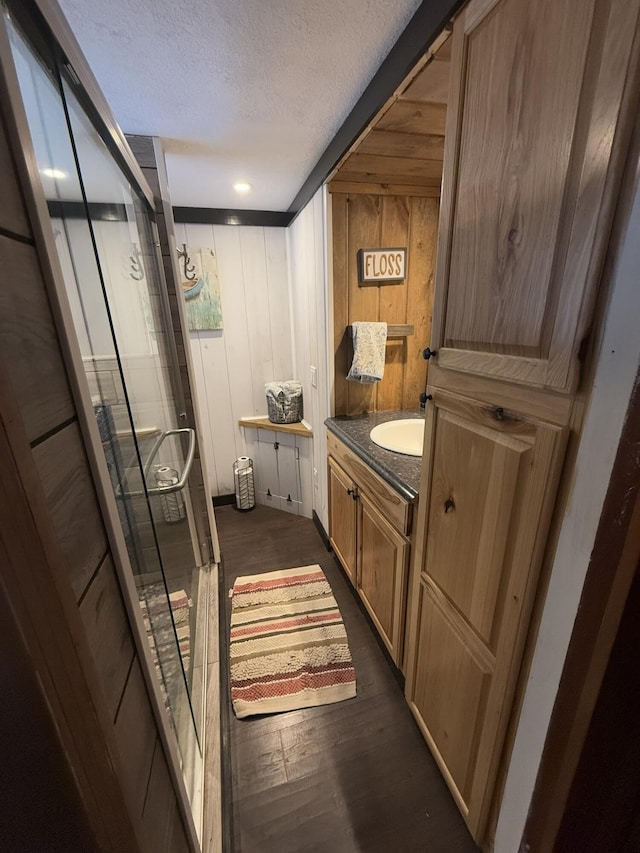 bathroom with hardwood / wood-style flooring, vanity, and a textured ceiling