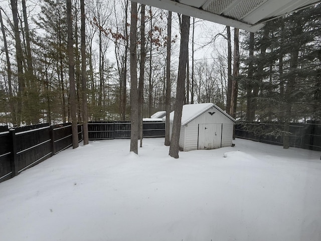 yard covered in snow featuring a storage unit