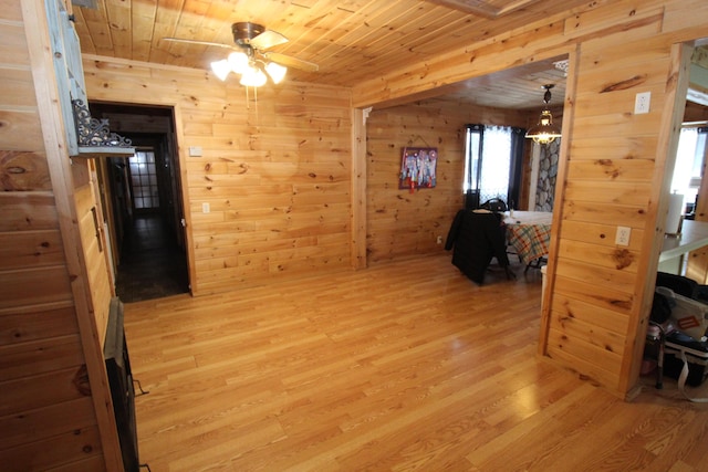 hall with wood walls, wooden ceiling, and light hardwood / wood-style flooring