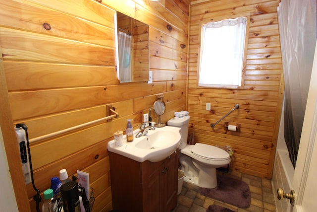 full bathroom featuring vanity, shower / bath combo with shower curtain, toilet, and wood walls