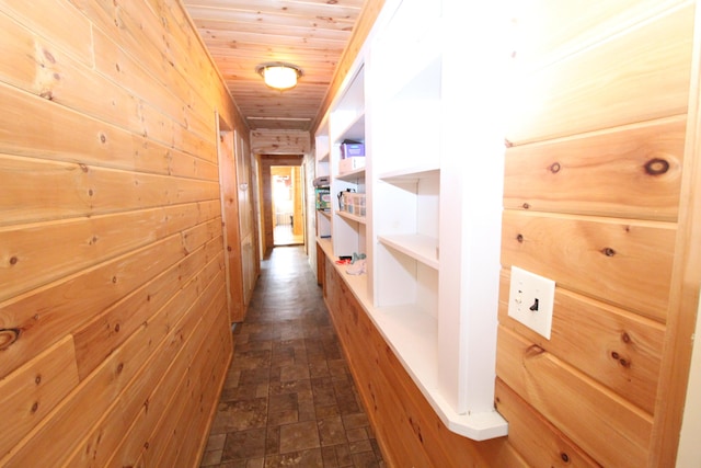 corridor featuring wood ceiling and wood walls