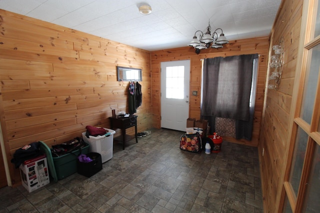 entrance foyer featuring wood walls and a notable chandelier