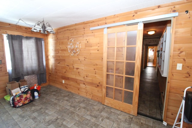 interior space featuring an inviting chandelier and wood walls