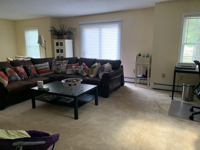 living room with a wealth of natural light, light colored carpet, and baseboard heating