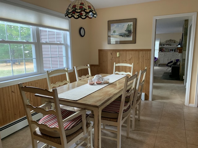 dining area featuring tile patterned floors and wooden walls