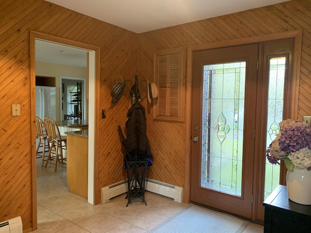 entrance foyer with light tile patterned floors, a baseboard radiator, and wood walls