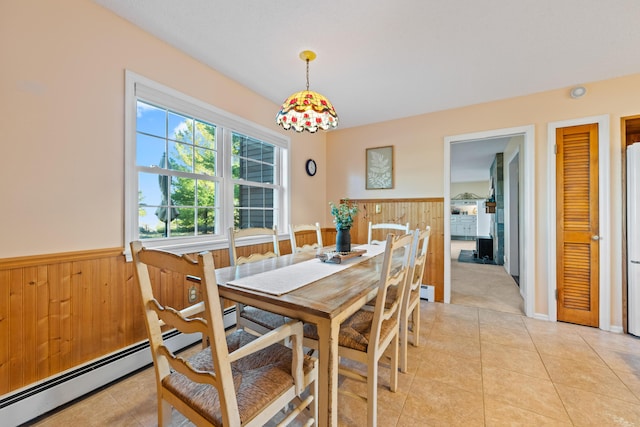 dining area featuring light tile patterned floors and wooden walls