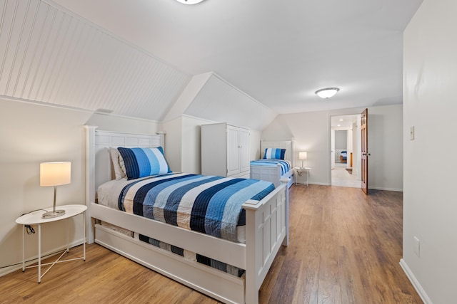 bedroom featuring lofted ceiling and hardwood / wood-style floors