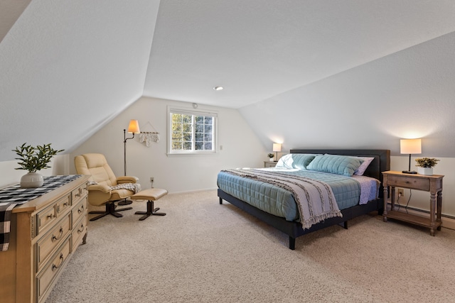 carpeted bedroom with baseboard heating and vaulted ceiling