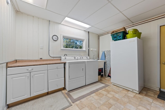 washroom featuring cabinets, washer and dryer, and wooden walls