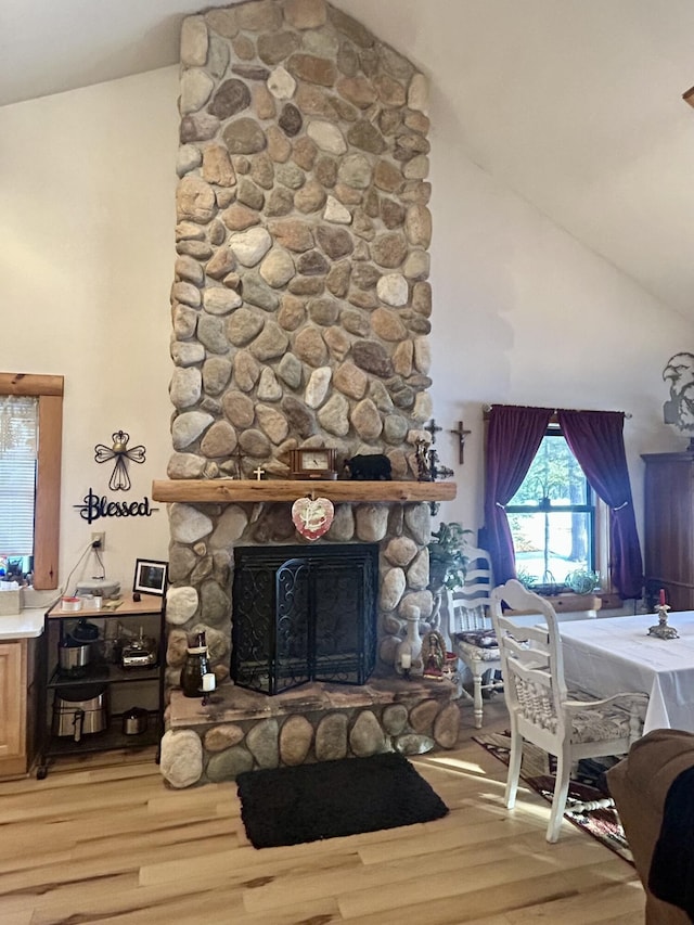 living room featuring a fireplace, wood-type flooring, and high vaulted ceiling