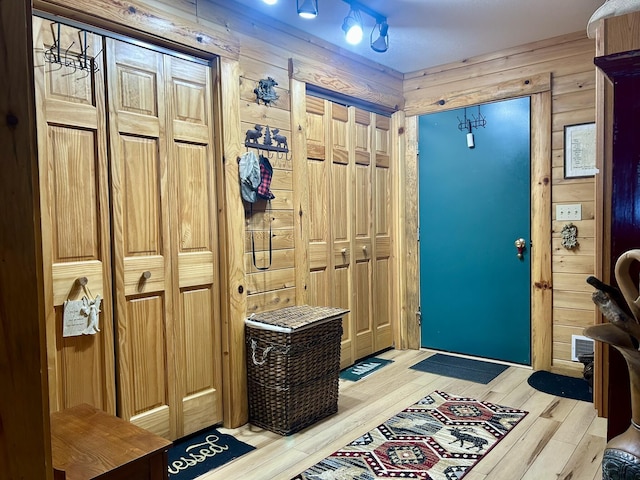 foyer featuring wood walls and light wood-type flooring