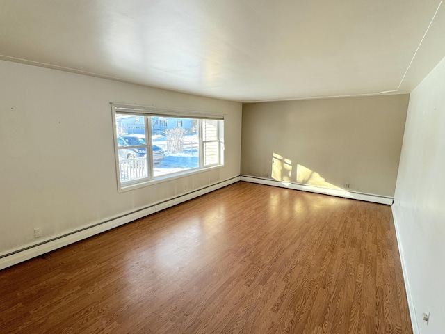 spare room with hardwood / wood-style flooring and baseboard heating