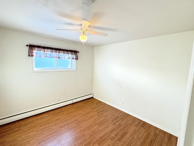 spare room with hardwood / wood-style flooring, ceiling fan, and a baseboard heating unit