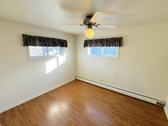 empty room featuring wood-type flooring, a baseboard heating unit, and ceiling fan