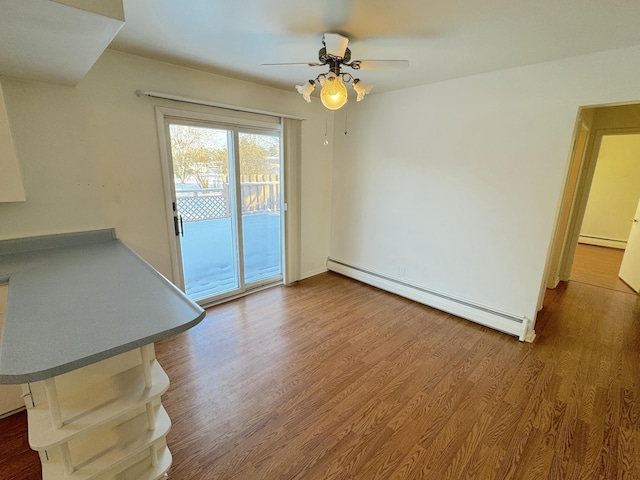 unfurnished living room featuring ceiling fan, a baseboard radiator, and wood-type flooring