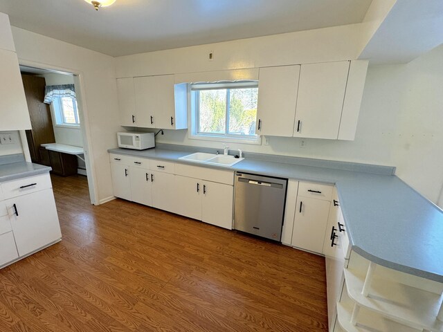 kitchen with sink, white cabinetry, plenty of natural light, stainless steel dishwasher, and light wood-type flooring