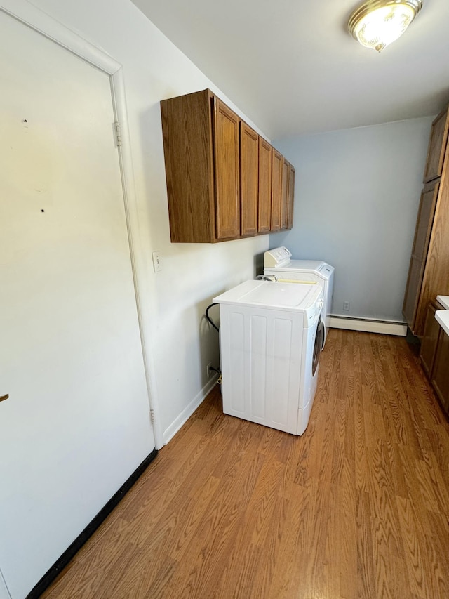 laundry area with cabinets, separate washer and dryer, light wood-type flooring, and a baseboard heating unit