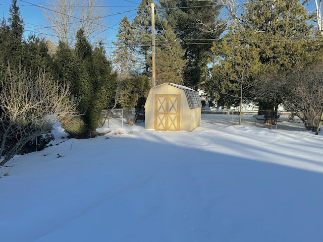 yard layered in snow with a shed