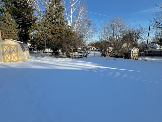 yard covered in snow with a shed