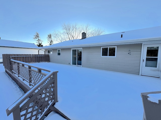 view of snow covered back of property