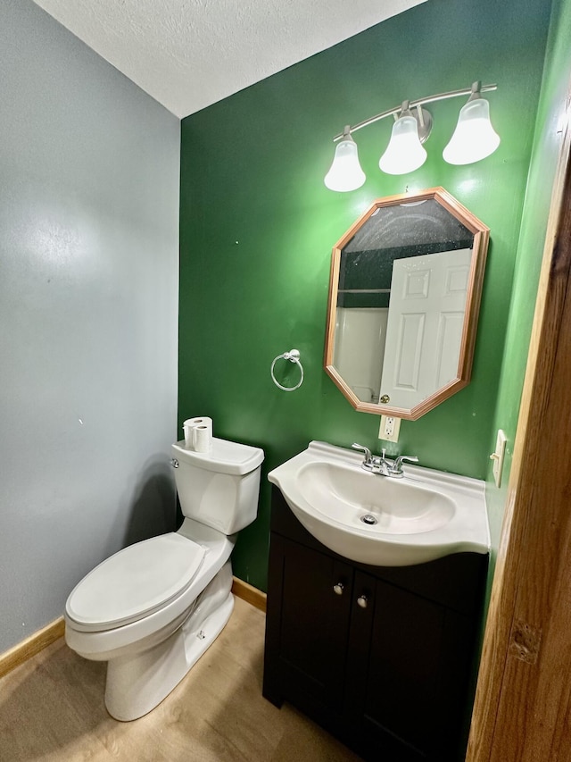 bathroom featuring vanity, a textured ceiling, and toilet