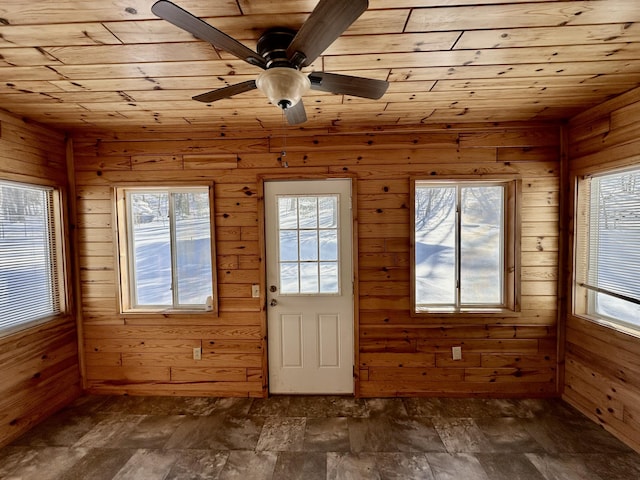 doorway to outside with wood ceiling, plenty of natural light, and wooden walls