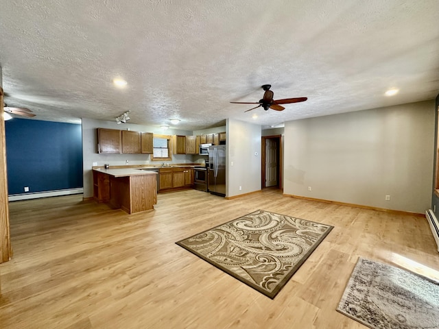 kitchen with ceiling fan, a baseboard radiator, stainless steel appliances, and light wood-type flooring