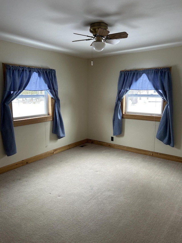 unfurnished room with ceiling fan, a healthy amount of sunlight, and carpet