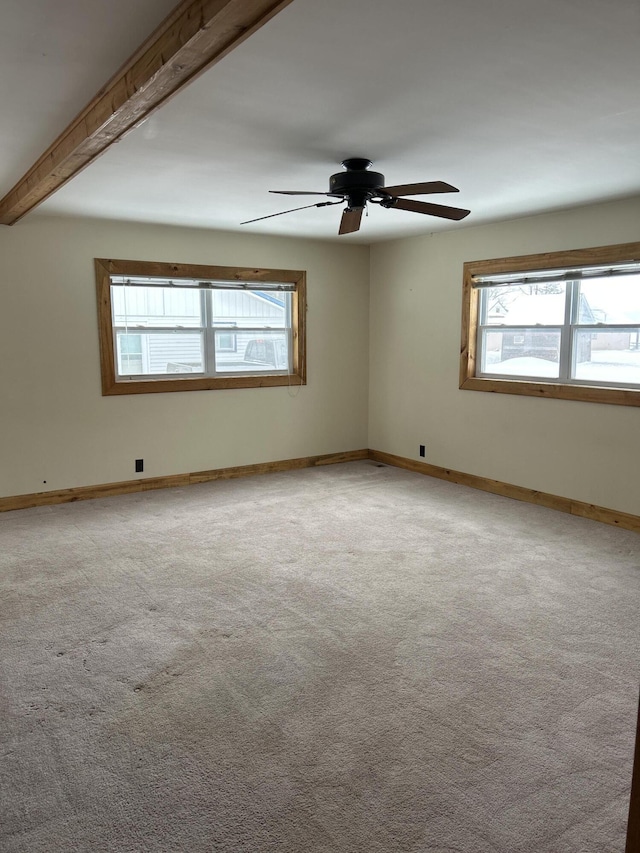 spare room with beamed ceiling, ceiling fan, and light carpet