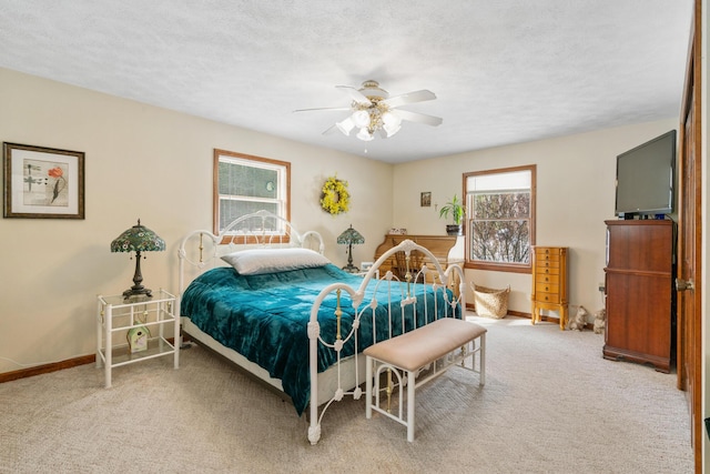 bedroom with ceiling fan, carpet, and a textured ceiling