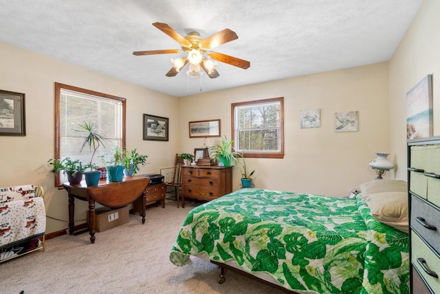 carpeted bedroom featuring ceiling fan and a textured ceiling