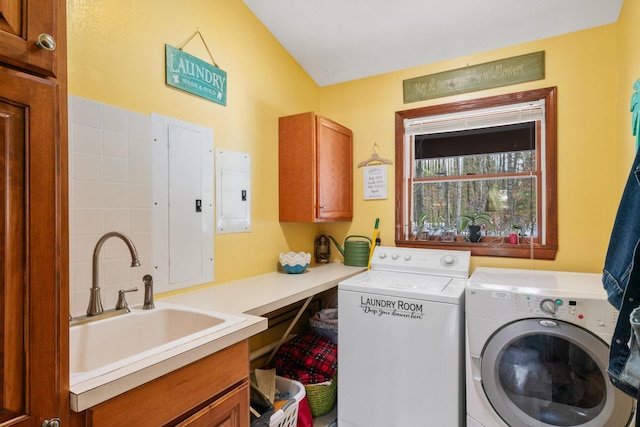 clothes washing area featuring cabinets, electric panel, sink, and washing machine and clothes dryer