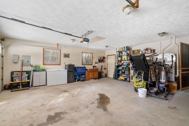 garage featuring a garage door opener, fridge, black fridge, and electric panel