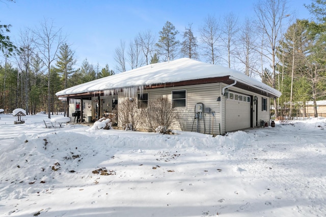 snow covered property featuring a garage