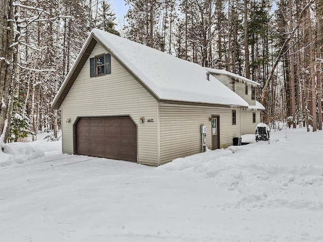 view of snowy exterior with a garage