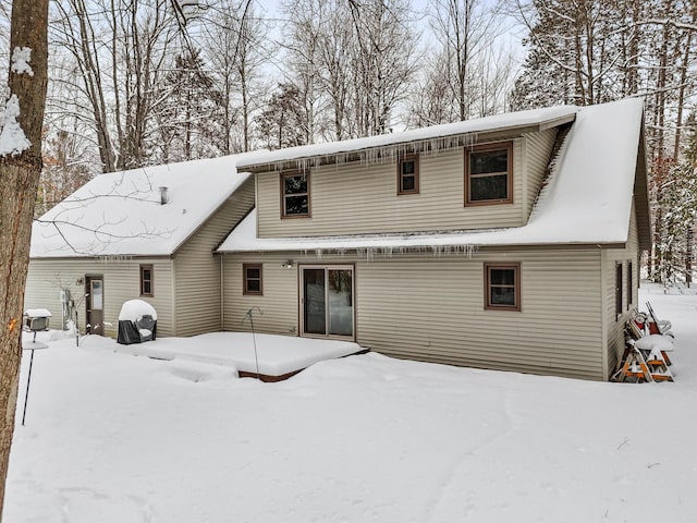 view of snow covered back of property