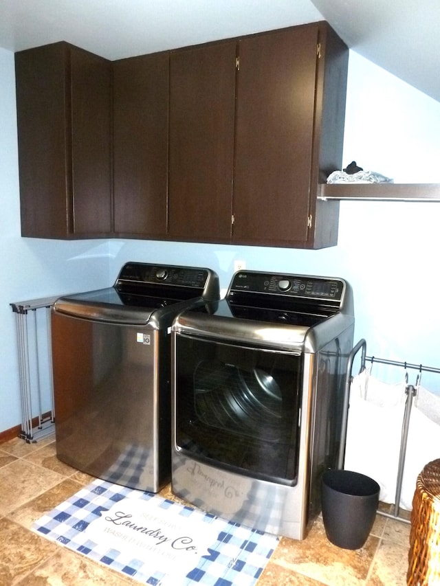 washroom with cabinets and washing machine and clothes dryer