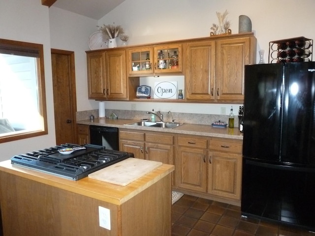 kitchen with lofted ceiling, butcher block counters, sink, dark tile patterned flooring, and black appliances