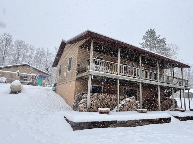 view of snow covered exterior featuring a wooden deck