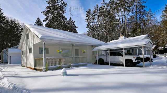 view of front of property featuring a garage, an outdoor structure, and covered porch