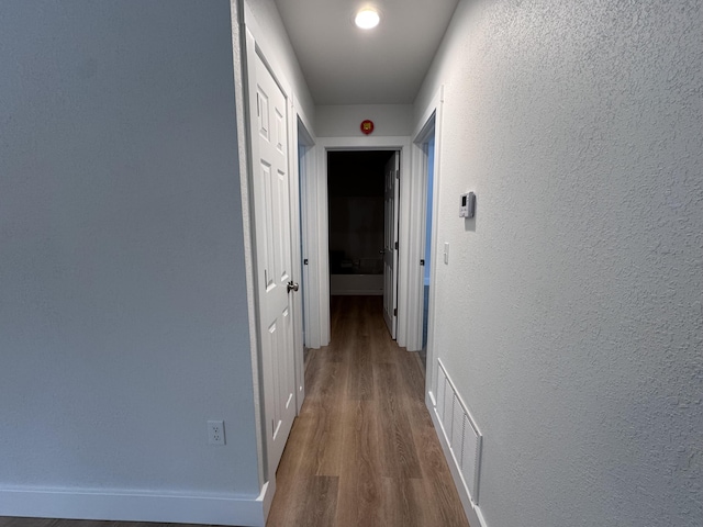 corridor featuring wood-type flooring