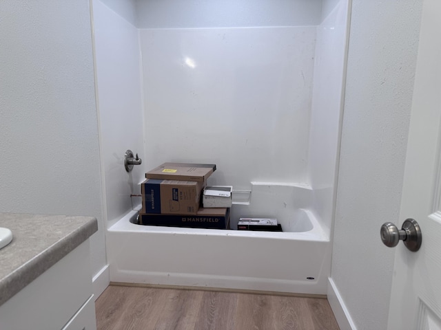 bathroom featuring a tub to relax in and hardwood / wood-style floors