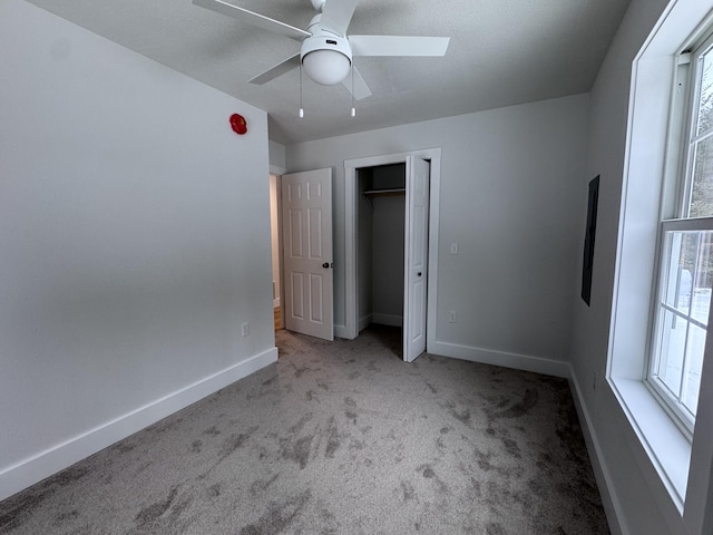 unfurnished bedroom featuring ceiling fan, light colored carpet, a closet, and multiple windows