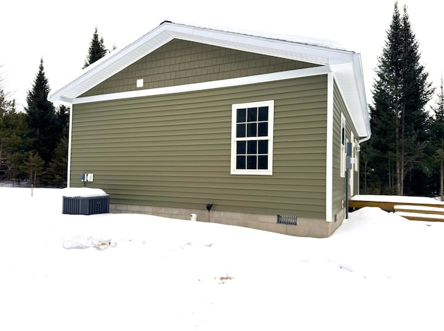 view of snowy exterior featuring central AC unit