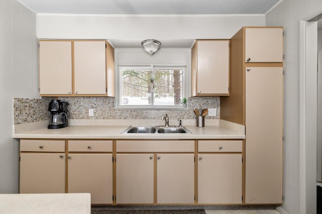 kitchen featuring cream cabinets, sink, and backsplash