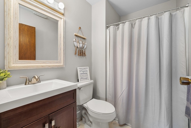 bathroom with walk in shower, vanity, and toilet